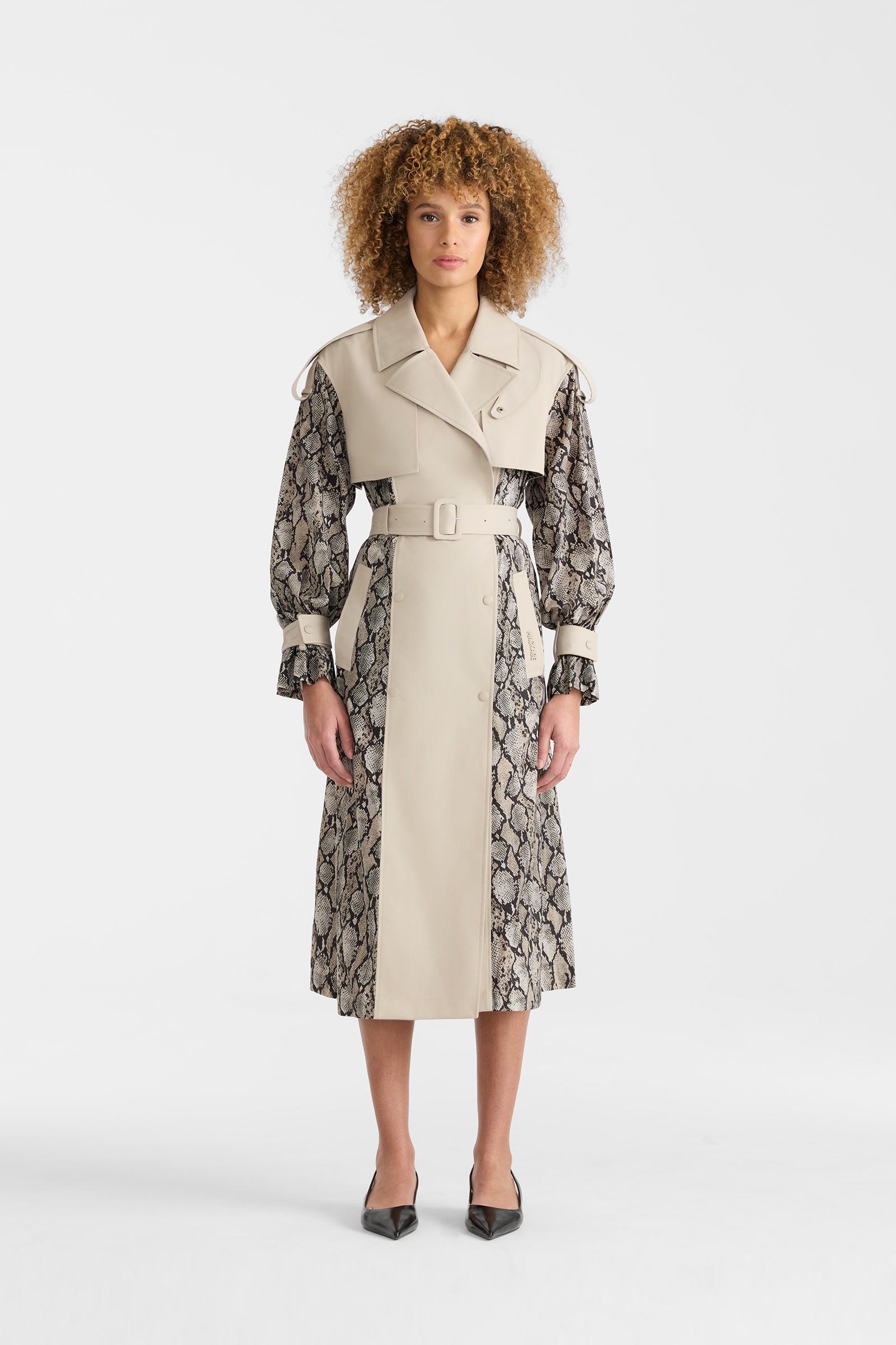 Woman wearing a lightweight snake pattern trench coat on a white background.