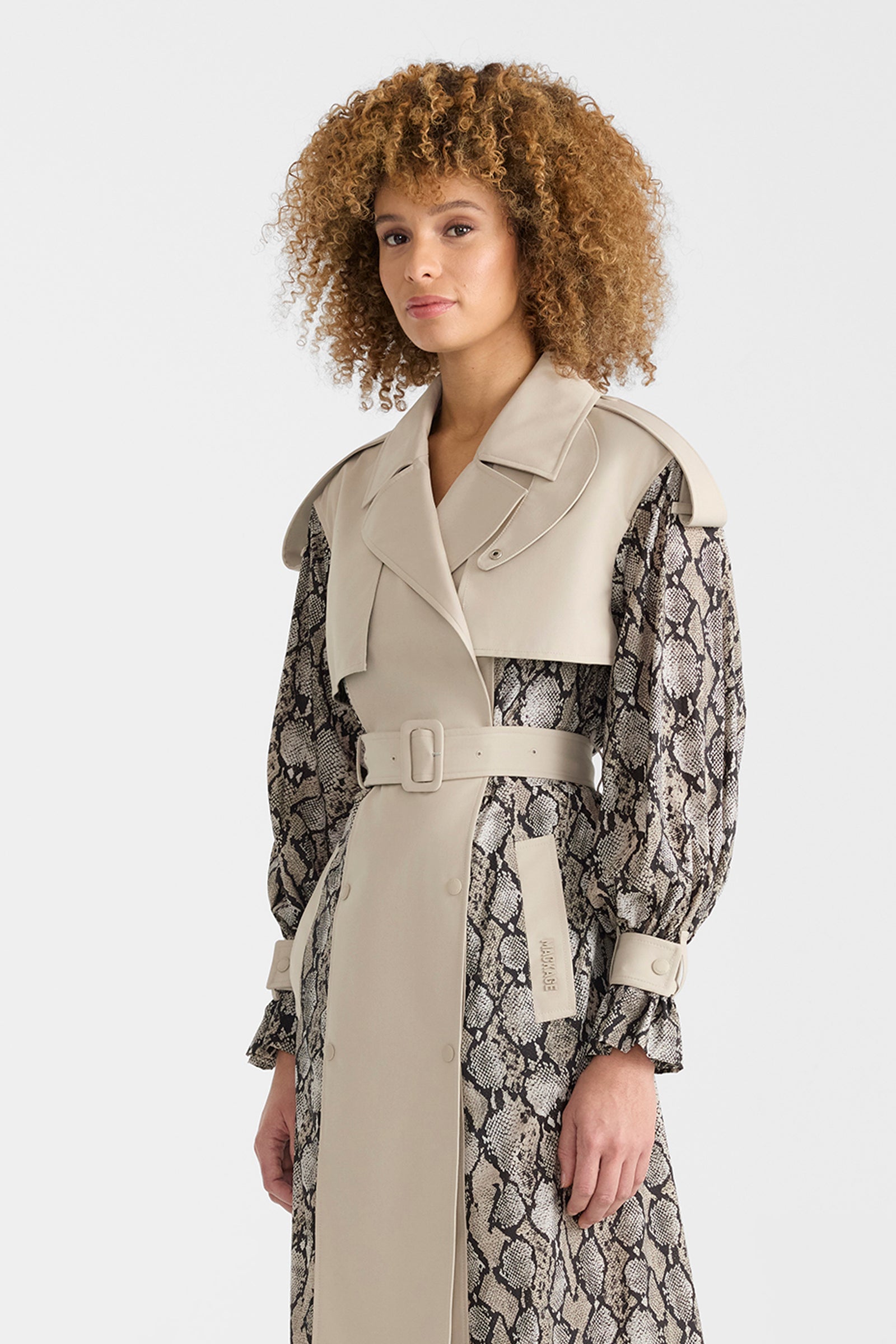 Woman wearing a lightweight snake pattern trench coat on a white background.