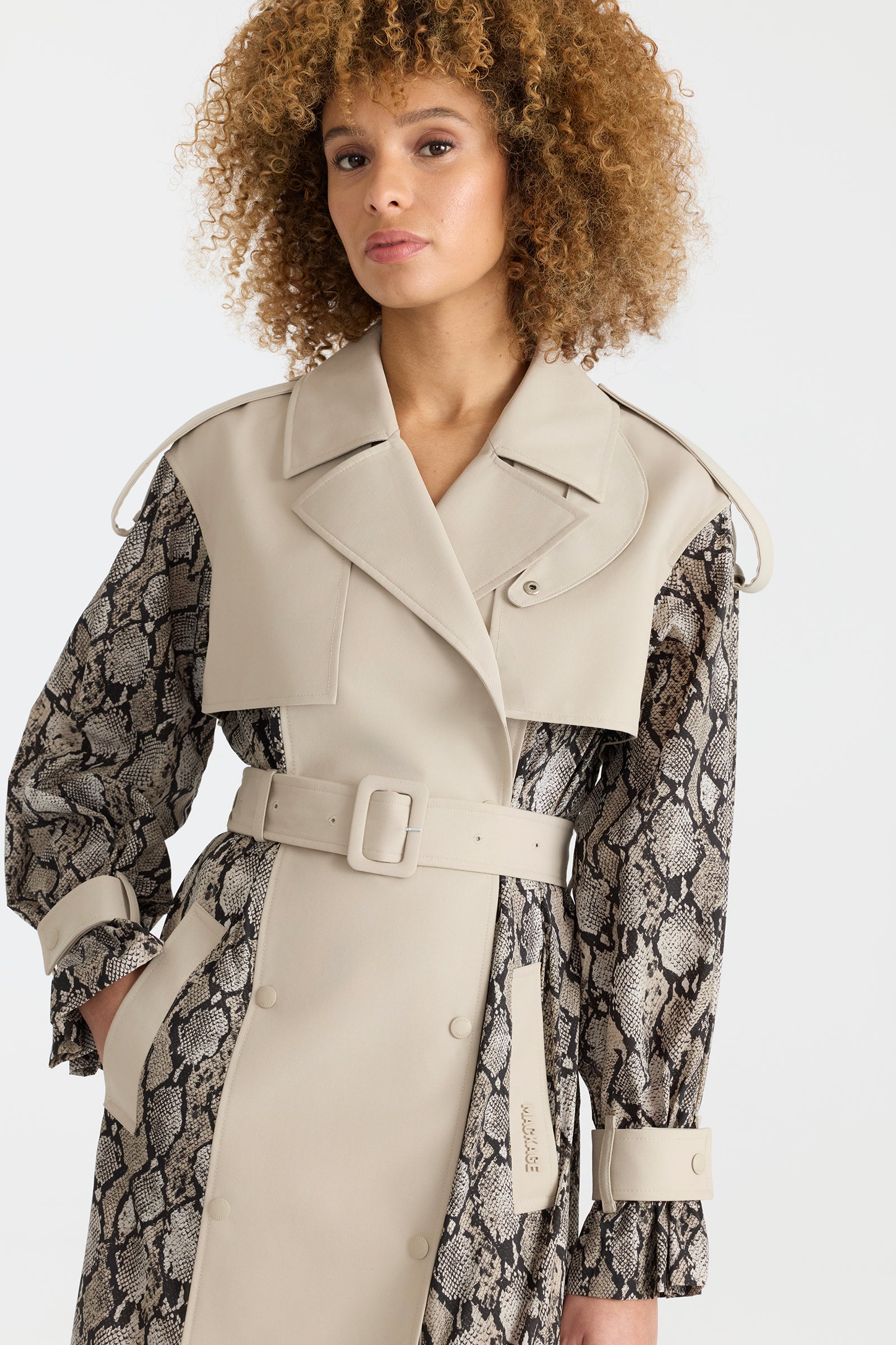Woman wearing a lightweight snake pattern trench coat on a white background.